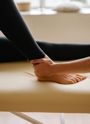 Close-up of a therapist performing a foot massage during a therapy session indoors.